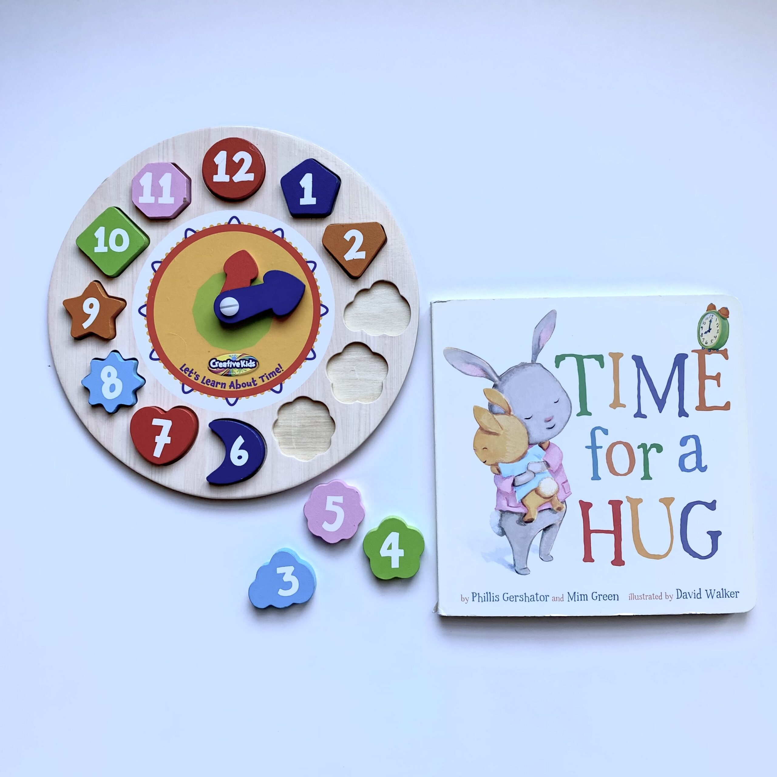 Time for a hug, toy clock and book about bunnies telling time.